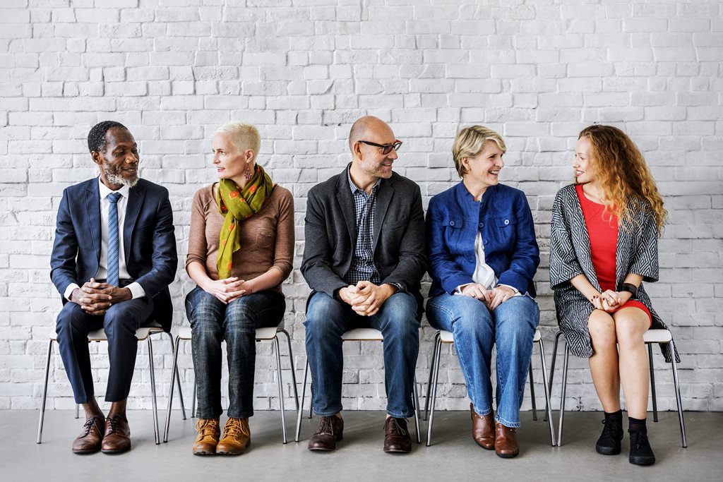 Ethnically diverse group of men and women sitting in chairs