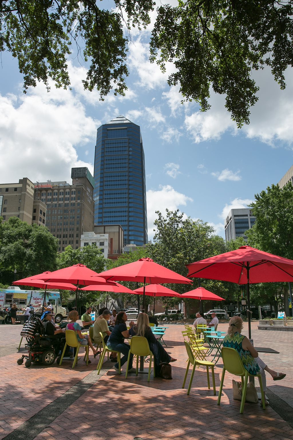 people eating lunch under umbrellas in hemming park