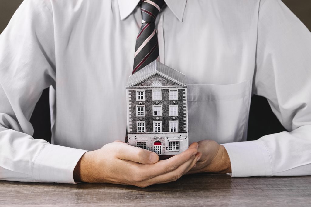 Man holding miniature house in hands