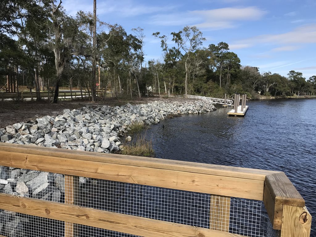 A wooden bridge, white rocks and a salt water.