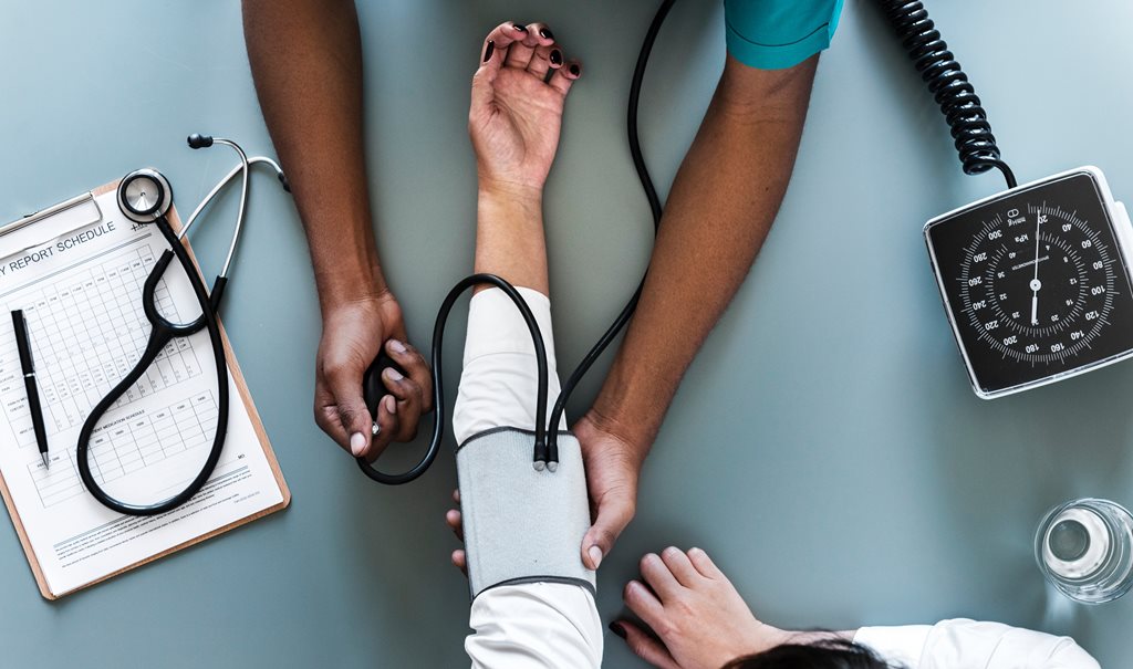 An aerial view of a medical professional taking the blood pressure reading of a patient