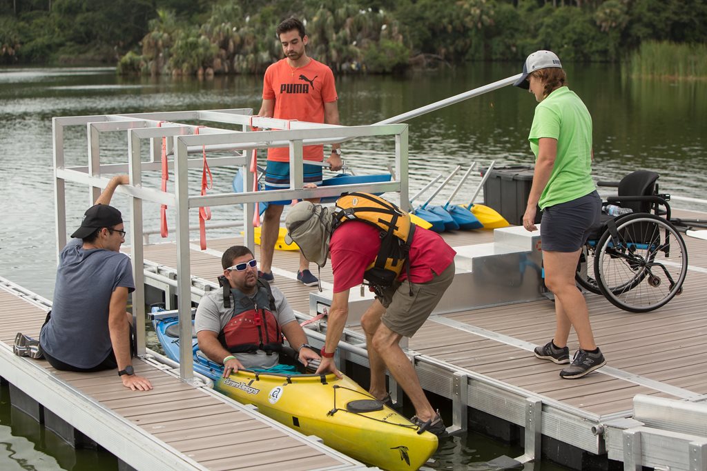 man getting into an adaptive kayak at hannah park