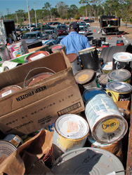 A City employee loading the dumpster at the Household Hazardous Waste collection event