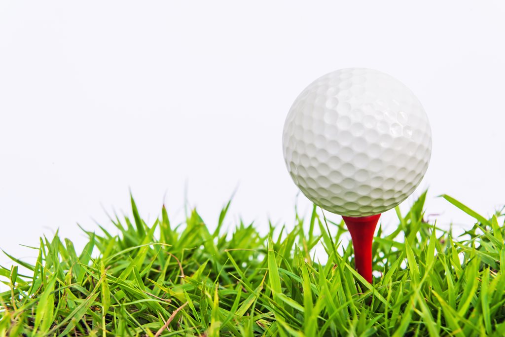 white golf ball sitting on a red tee