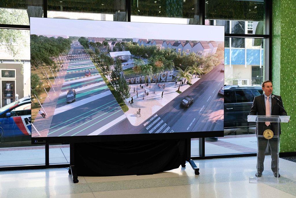 Mayor Lenny Curry standing at a podium speaking about new park with picture of the design on a screen