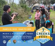 park naturalist holding a turtle as on-lookers listen to story