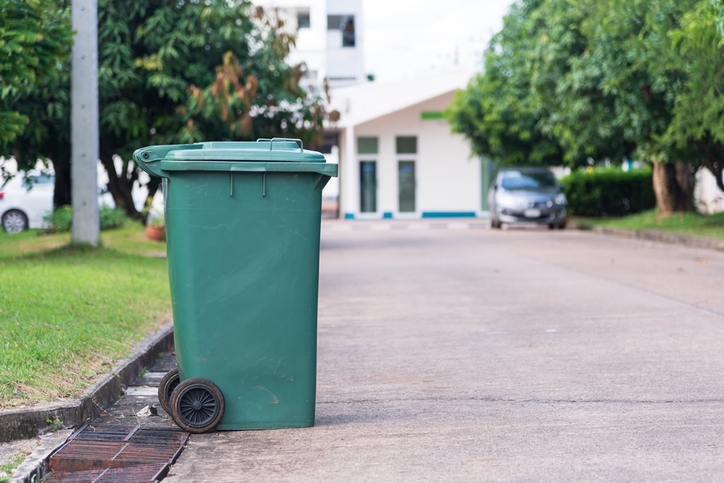 green trash cart on curb