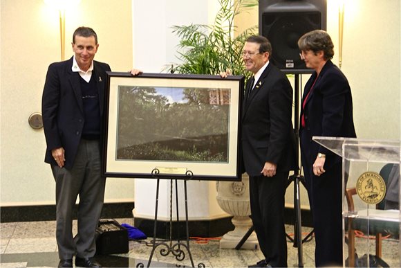 Photo of Council Member Jim Love recieving the Keep Jacksonville Beautifull Jake Godbold award from Kevin Gartland and Chris Buckley.  The award is a framed landscape artwork.