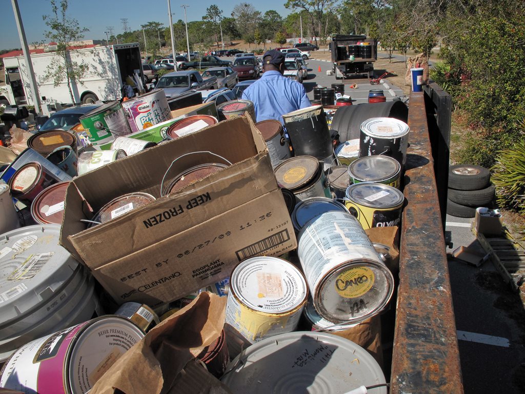 disposal truck filled with old paint cans