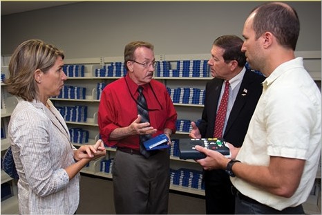 Photo of Council Member Jim Love discussing the Talking Books / Special Needs Library, with Library Board Trustee Erin Vance Skinner and Jerry Reynolds, Library Manager of Special Services.