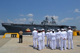 Photo of sailors on watching the docking of the USS Iwo Jima at Naval Station Mayport.