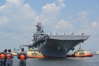 Photo of the tug boats turning the USS Iwo Jima toward the dock at Naval Station Mayport.