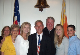 Photo of Council Member Doyle Carter with his family and Chief Judge Donald Moran.  Shown from left to right are Councilman Carter's sister, Annette Jones, mother Shirley Carter, wife Trish, Councilman Carter, Judge Moran, daughter Heather, and son DJ.